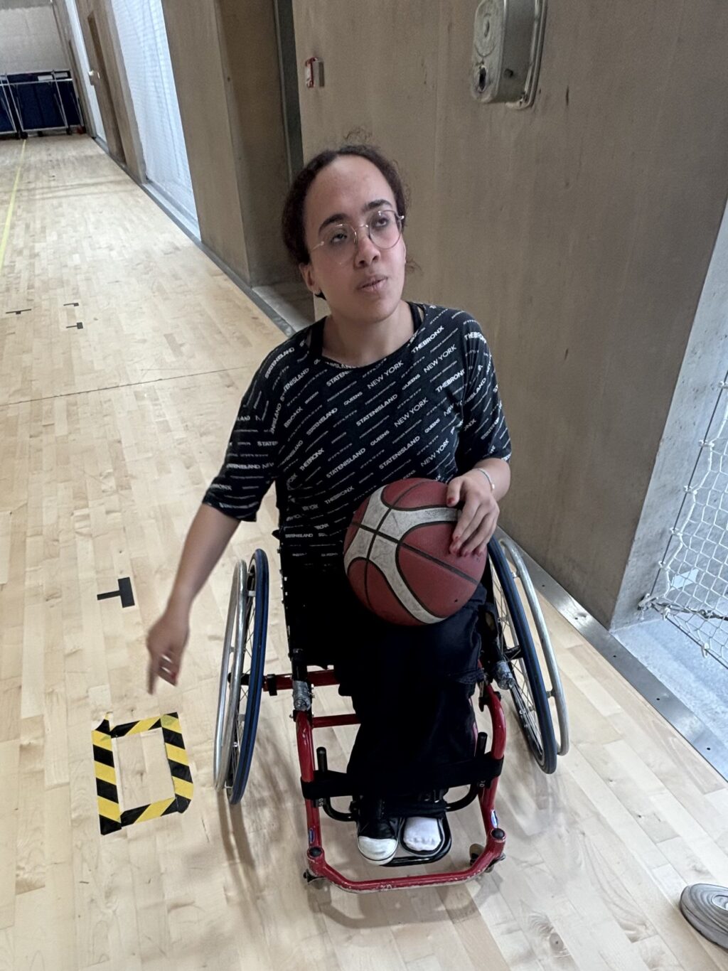 Ranim, joueuse de basket fauteuil s’amusant au bord du terrain. Crédit : Yoni Bisror